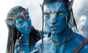 Two blue-skinned, humanoid aliens with yellow eyes and braided hair stand close together, wearing beaded jewelry and tribal adornments. One looks serious while the other gently rests a hand on his shoulder.