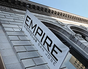A white banner reading EMPIRE NIGHTCLUB SAN JOSE is mounted on the exterior of a stone building with arched windows. The photo is taken from a low angle, showing part of the ornate facade.