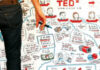 A person holding markers stands in front of a colorful illustrated board with sketches, text, and TEDx branding, actively drawing or writing on the board.