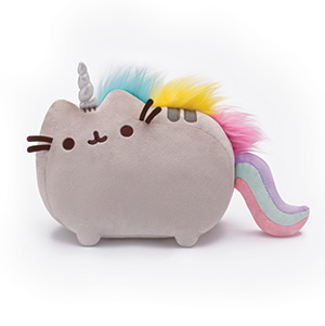 A plush toy shaped like a cat with a unicorn horn, brown whiskers, rainbow-colored mane, and a pastel rainbow tail. The toy is soft, gray, and has a cute, smiling face.
