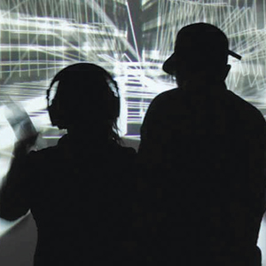Two people in silhouette, one wearing headphones and the other a cap, stand in front of a digital background with abstract, white, geometric lines and shapes.