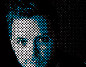 A portrait of a man rendered in a halftone pattern, with blue and white dots creating highlights on his face against a black background.