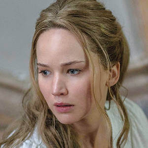 A woman with long, wavy blonde hair looks to the side with a concerned expression. She is wearing a white top and the background is out of focus.