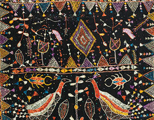 Colorful traditional textile with intricate embroidery showing two birds facing each other, surrounded by fish, abstract patterns, geometric shapes, and small animals on a dark background.