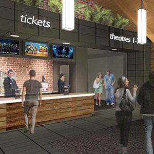 A movie theater lobby with people walking and standing near a ticket counter. Signs above read tickets and theatres 1-7. Movie posters, including Toy Story, are displayed above the counter.