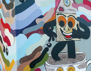 Colorful mural featuring a cartoonish figure with a house-shaped head and large orange eyes standing on a coffee cup, surrounded by swirling, multicolored abstract shapes and another face drawn on the cup.