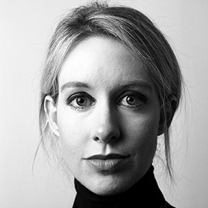 Black and white portrait of a woman with light hair pulled back, wearing a dark turtleneck, looking directly at the camera with a neutral expression against a plain background.