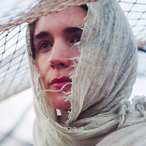 A person with light skin and pink lips wears a tattered, light-colored scarf over their head and shoulders, looking thoughtful. Mesh netting is draped above and behind them.