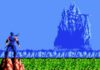 A pixelated ninja stands on a cliff, overlooking a vast field and a towering, jagged blue mountain in the distance beneath a clear blue sky.