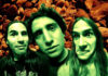 Distorted, green-tinged faces against a brown background