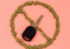 Single car key covered by the sign for "No" (circle with an X through it) made of crumbled marijuana