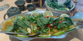 Fish covered with basil leaves on a fish-shaped platter