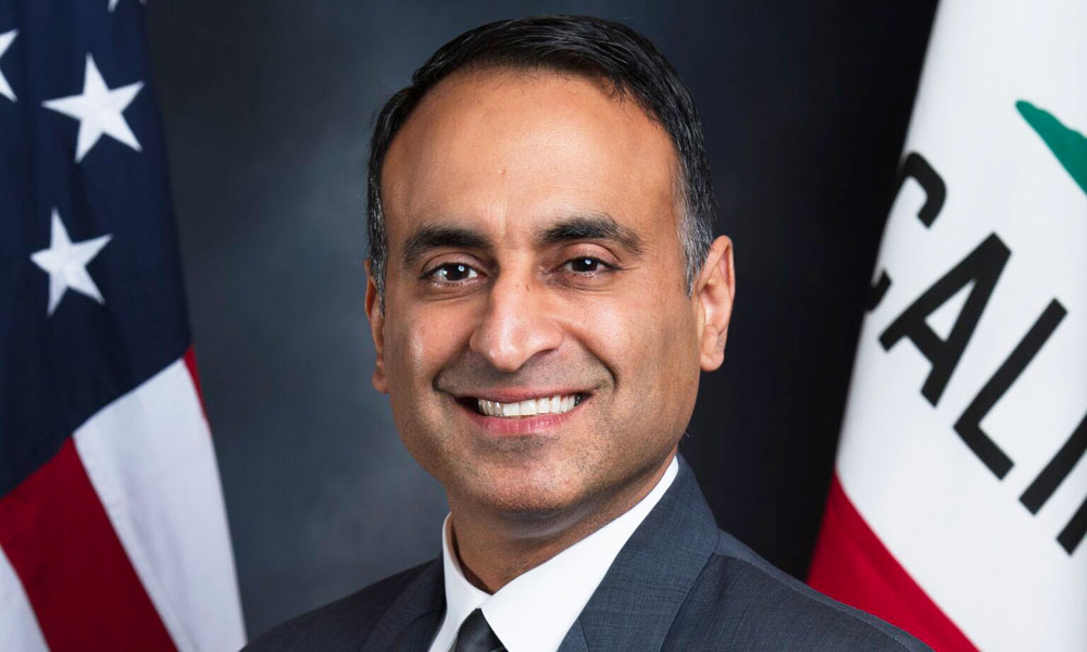 Portrait of assemblymember in front of American and California flags