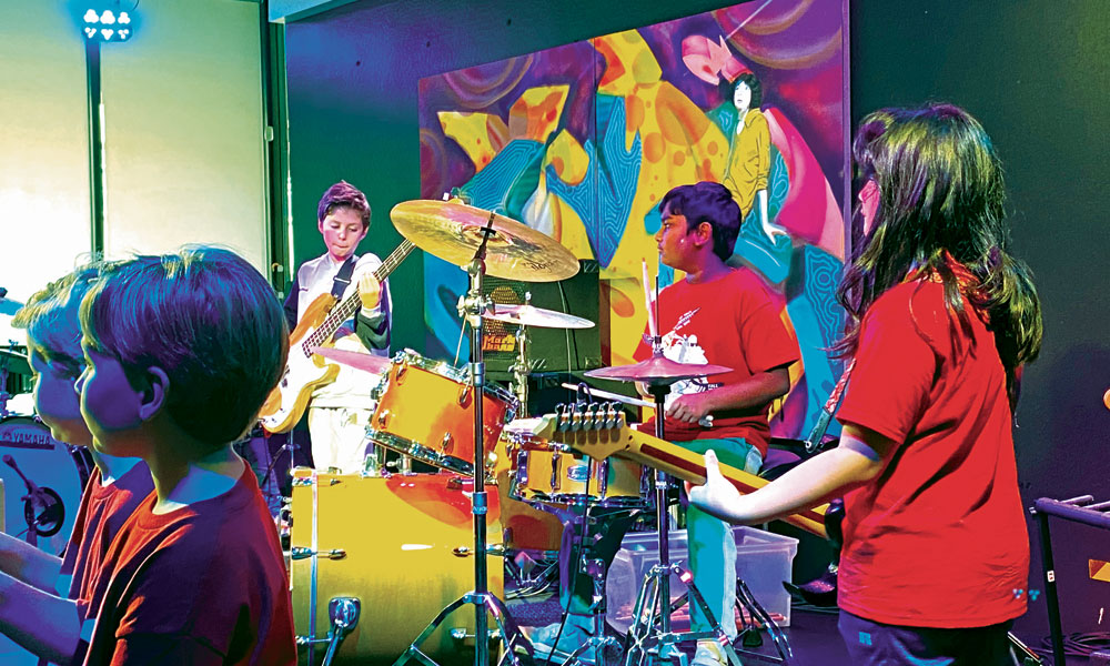 Young kids playing rock instruments on a stage
