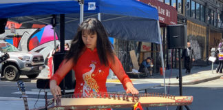 Woman playing musical instrument on a city street