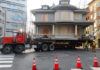 Old house being moved on the back of a flatbed truck