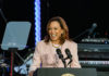 Kamala Harris speaking into a microphone at a podium