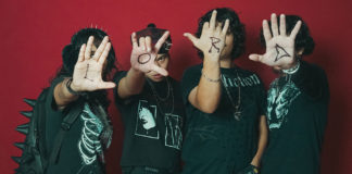 Musicians with faces covered by their open palms, with letters written on them that spell out LORD