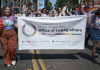 Parade with members of the Santa Clara County Office of LGBTQ Affairs marching with a banner