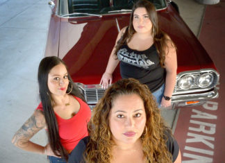 Three women standing in front of a car