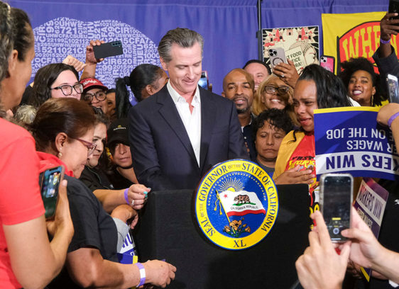 California governor at podium surrounded by a crowd
