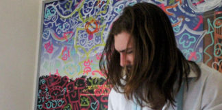 Man with his head looking down while he drums