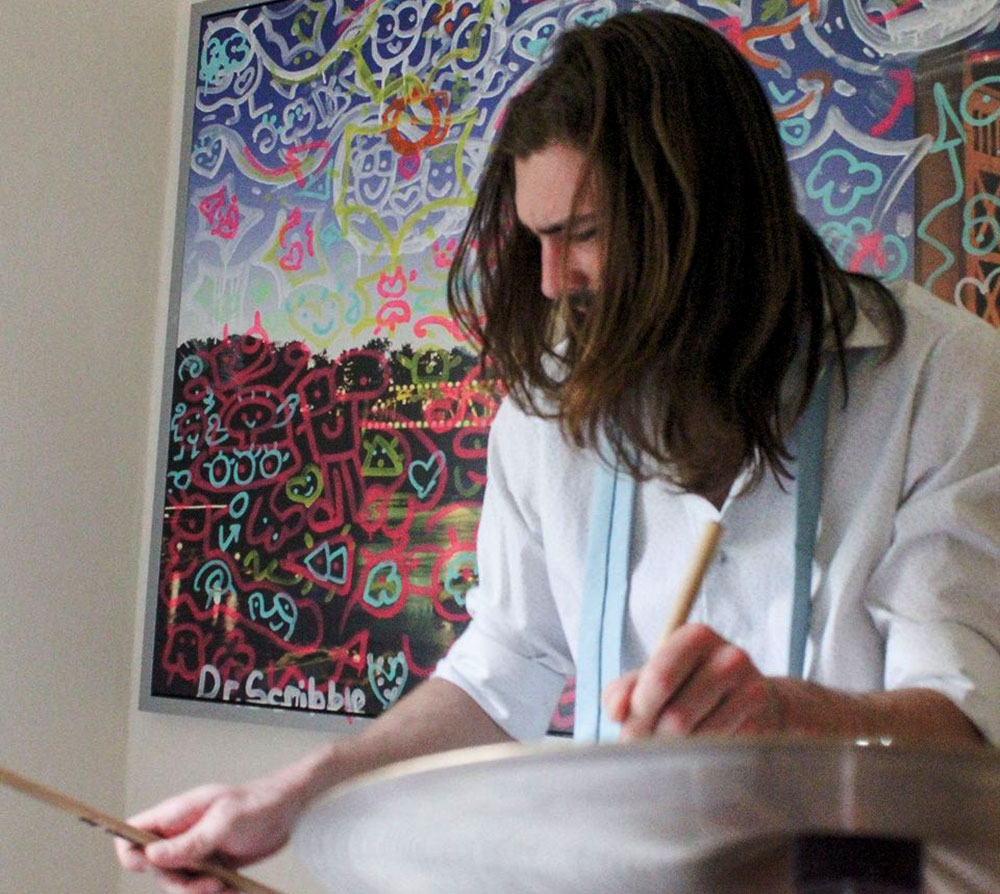 Man with his head looking down while he drums