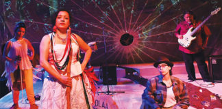 People performing on a stage in costumes and playing instruments