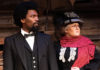 Black man and white woman in 19th century clothing on a stage