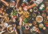Arms outstretched over a table loaded with food