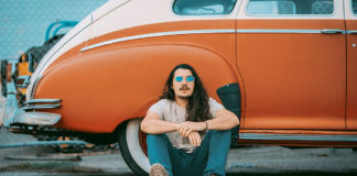 Man sitting in front of a vintage sedan