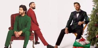 Three men and a Christmas tree on a light-colored background