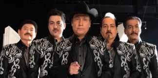 Five men in black suits with decorative white designs