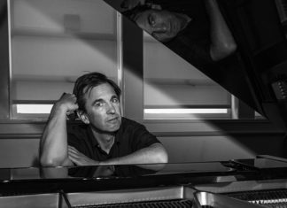 Black-and-white photo of a man sitting at a piano