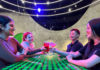 Group of four young adults sitting around a table in a brightly colored lounge