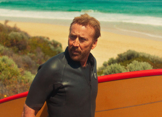 Man carrying a surfboard down to the beach