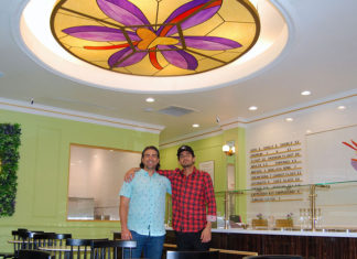 Two men in a brand-new ice cream shop with a stained-glass decoration in the ceiling