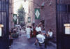 People sittlng on a narrow brick-lined patio