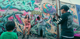 Musicians performing in front of a graffiti-covered wall