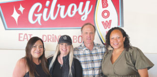 Four people in front of a sign for Gilroy Bowl