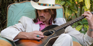 Man sitting down holding a guitar
