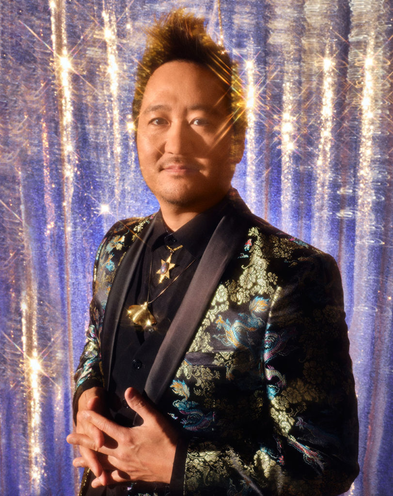 Man on stage wearing a flowered satin jacket