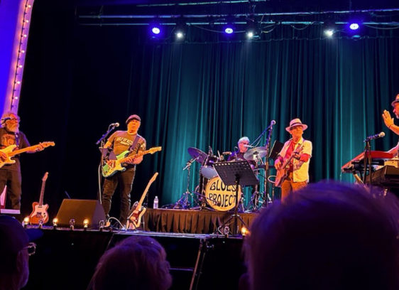 Musicians on a stage, photographed from the aucience