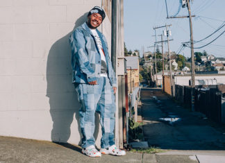 Man leaning against a wall in an urban neighborhood