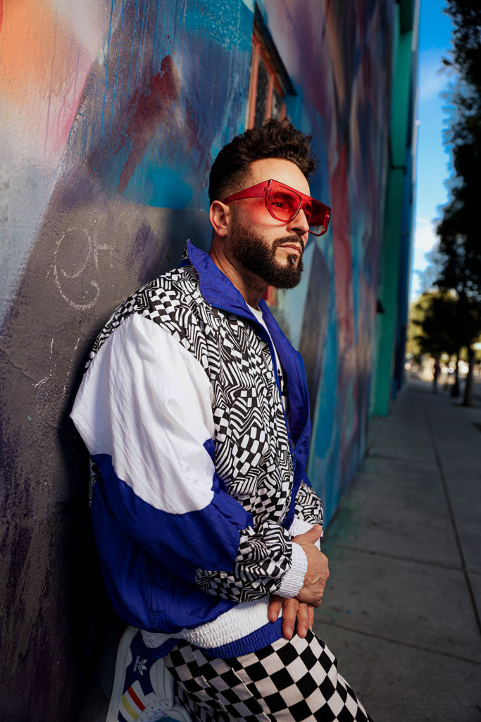 Man leaning against a wall with a mural painted on it