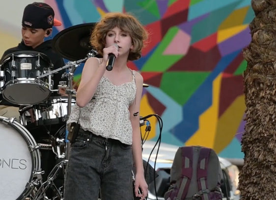 Kids onstage—one singing, one drumming