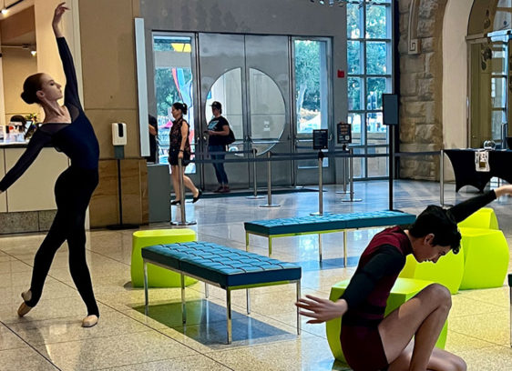 Dancers pose in a museum foyer