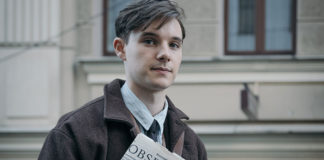Young man holding a newspaper on the street