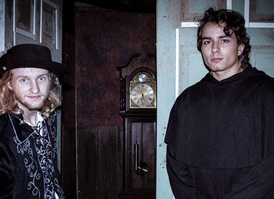 Two young men standing in front of a doorway