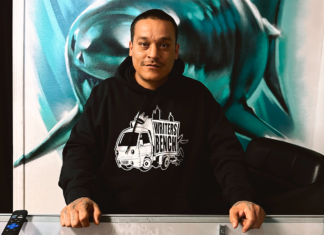 Man standing in front of a painting of a shark